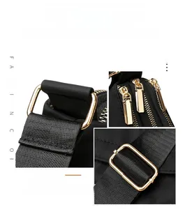 Detail of high-quality gold metal hardware and durable nylon fabric on a crossbody bag