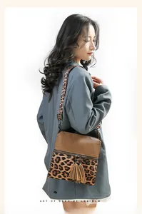 Détail du sac bandoulière léopard avec de longs glands et bandoulière sur le modèle