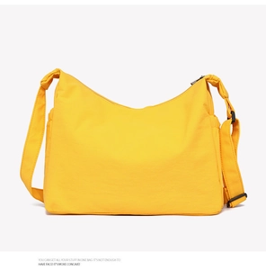 Detail of a bright yellow large-capacity nylon tote bag with adjustable shoulder straps