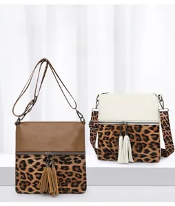 Détail de sacs bandoulière imprimé léopard avec doubles pompons et larges bandoulières
