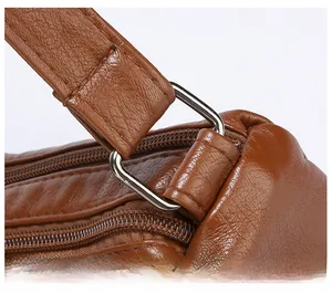 Gros plan sur les anneaux métalliques et la texture cuir marron de ce sac à bandoulière