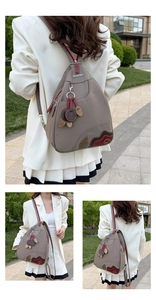Close-up of waterproof Oxford fabric backpack with floral embroidery and brand charm