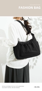 Detail of minimalist black canvas tote bag showing drawstring pocket and textured fabric