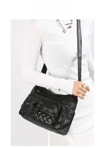 Détail d'un sac bandoulière noir multi-poches avec texture matelassée sur modèle