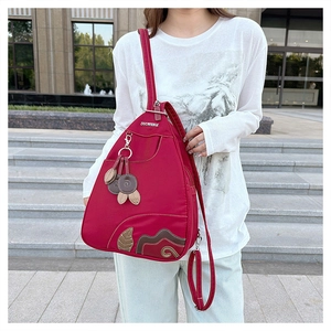 Close-up of red waterproof nylon teardrop backpack with patchwork leaf embroidery detail