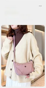 Sac bandoulière rose en nylon style dumpling avec bandoulière réglable porté par un modèle