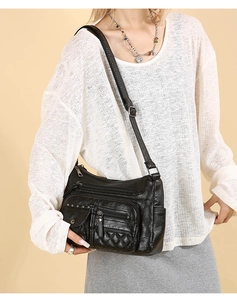 Détail du sac bandoulière noir avec multi-fermetures éclair et motif matelassé
