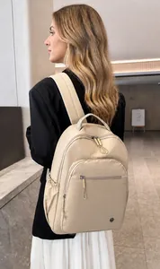 Macro detail of beige lightweight nylon backpack featuring dual zippers and side pocket