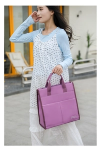 Close-up of a purple canvas tote bag with front pockets shown in a street style setting