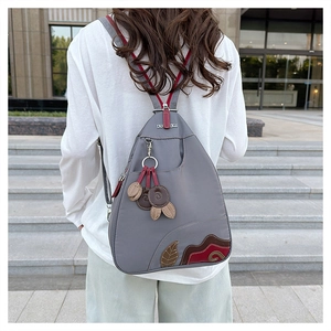 Detail of waterproof gray nylon backpack with leaf embroidery and adjustable zipper straps
