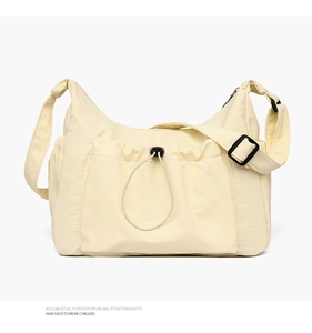 Close-up of beige canvas tote bag with functional drawstring front pocket and adjustable strap