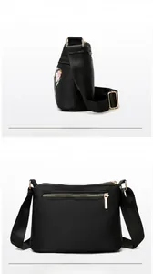 Detailed views of nylon crossbody bag with floral embroidery and gold hardware