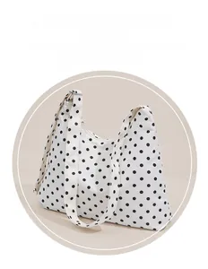 Detail view of the stylish black polka dot pattern on the white canvas tote bag material