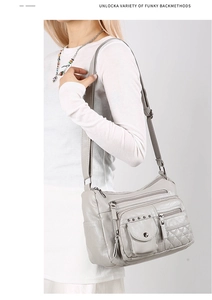 Détail du sac bandoulière gris clair en cuir souple matelassé avec plusieurs poches