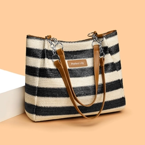 Black and white striped woven tote bag with brown leather handles and silver chain detail