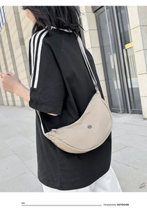 Dettaglio borsa a tracolla a mezzaluna in nylon kaki con tracolla regolabile e logo