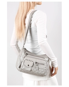 Détail du sac bandoulière gris clair avec texture matelassée et rivets argentés chic