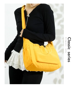 Detailed view of yellow nylon crossbody bag with multiple pockets and functional side pockets