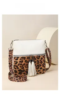 Détail du sac bandoulière léopard avec pompons blancs et large sangle amovible