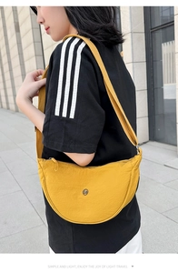 Dettaglio della borsa a mezzaluna in nylon giallo con ampia tracolla regolabile