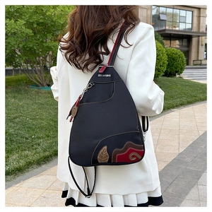 Detail of waterproof nylon chest bag featuring colorful leaf embroidery and brand leather label