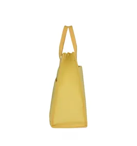 Side view of yellow canvas office tote bag showing durable stitching and trapezoid structure