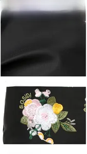 Macro shot of floral embroidery on high-density black nylon fabric shoulder bag