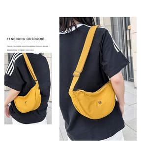 Dettaglio della borsa a tracolla in nylon giallo brillante a forma di mezzaluna con logo