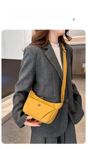 Détail d'un sac bandoulière en nylon jaune vif avec sangle réglable et poche avant zippée