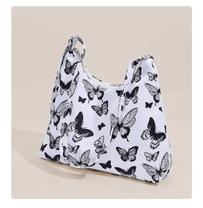 Detail of white canvas underarm bag with black butterfly prints and silver metal zipper