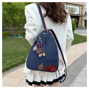 Detail of waterproof nylon shoulder bag with leaf patterns and metal logo pendant