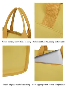 Detail of yellow canvas tote with reinforced handles and rear zipper tablet pocket