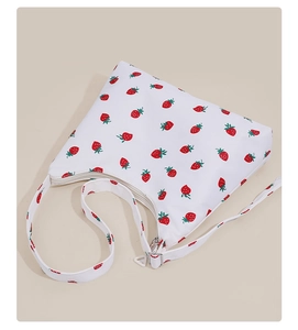 Detail of white underarm bag with red strawberry print and zipper closure