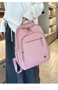 Detailansicht des rosa Nylon-Rucksacks mit Metallreißverschlüssen und Seitentasche