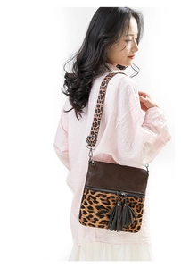 Détail du sac bandoulière léopard avec double pompon et fermeture éclair métallique