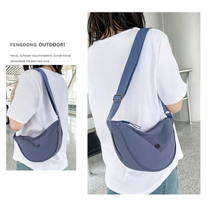 Dettaglio della borsa a tracolla in nylon blu con tracolla regolabile e cerniera