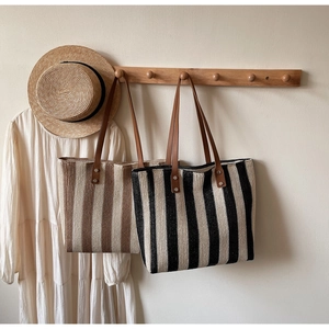 Detail of straw woven tote bag texture with leather handle and metal rivet reinforcement