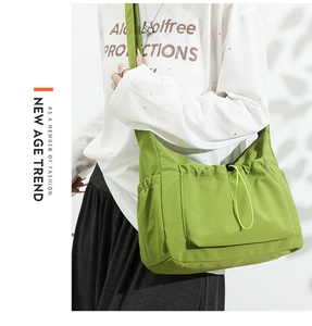 Detailed side view of grass green canvas tote bag with functional drawstring front pocket