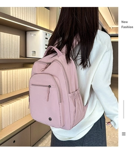 Detailaufnahme des leichten rosa Nylon-Rucksacks mit Hauptfach und Metall-Logo-Akzent