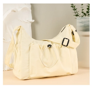 Close-up of cream canvas tote bag showing adjustable strap and functional drawstring pocket