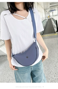 Dettaglio della borsa a mezzaluna in nylon blu Morandi indossata per viaggi leggeri