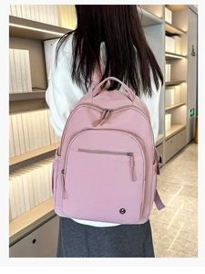 Detailansicht des rosa wasserdichten Nylon-Rucksacks mit Reißverschlusstaschen und Seitenfach