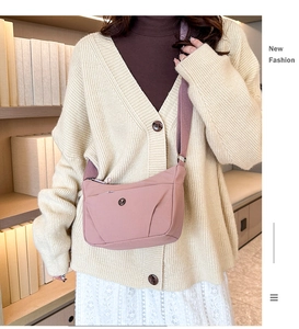 Détail du sac bandoulière en nylon rose avec large sangle réglable au style décontracté