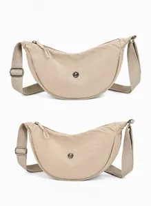Vista frontale e laterale della borsa a mezzaluna in nylon beige con tracolla regolabile