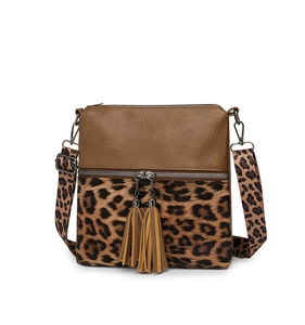 Détail du sac bandoulière léopard avec fermetures à glands et cuir marron texture