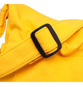 Detail of yellow canvas tote bag showing black adjustable strap buckle and fine stitching