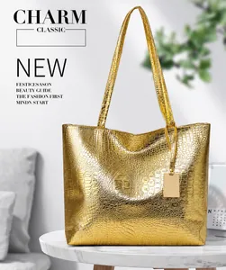 Detailed close-up of golden crocodile pattern leather tote bag with metallic logo charm