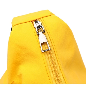 Detail of a bright yellow canvas tote bag featuring a high-quality silver metal zipper