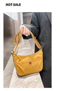 Détail du sac bandoulière en nylon jaune avec zip frontal et large sangle réglable
