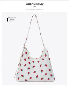Close-up of white underarm bag with strawberry print and adjustable shoulder strap